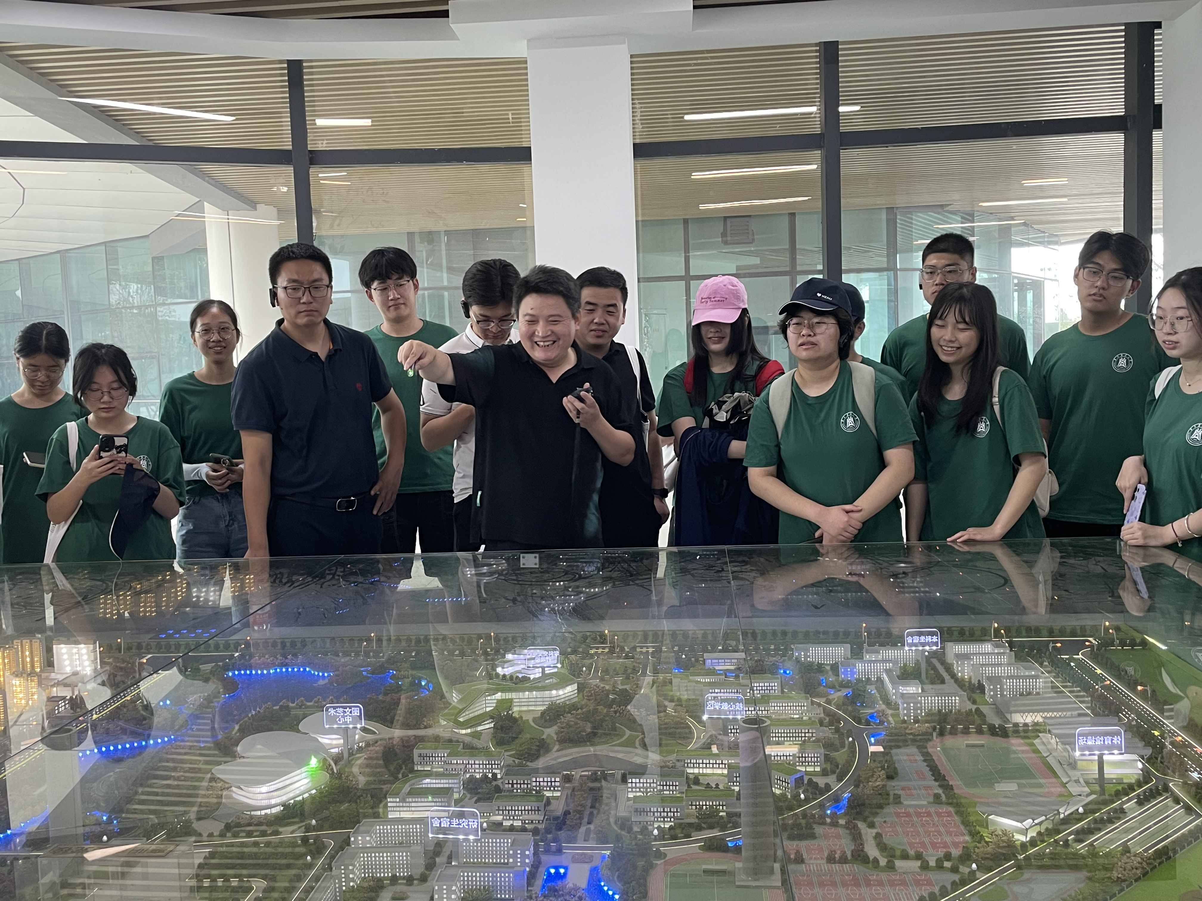 王君(左7)为实践团成员讲解院区沙盘(通讯员 李昕怡 摄)